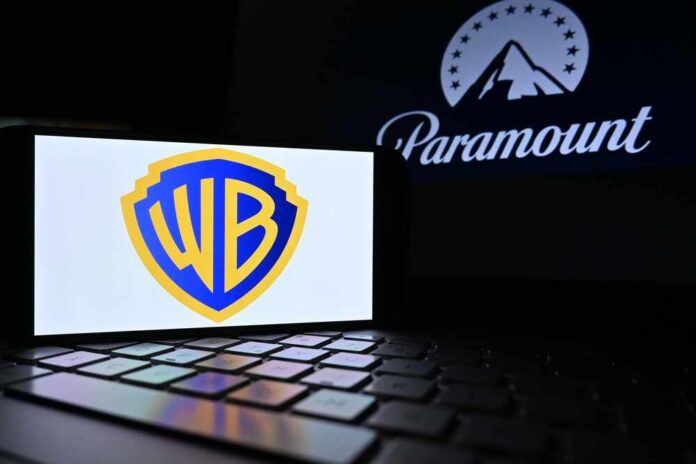 Paramount,And,Warner,Bros,Logos,Appear,On,The,Screen.,Paramount Warner Bros logo displayed on a smartphone with Paramount logo in the background