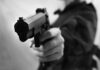 Close-up of a person holding a handgun in a threatening manner