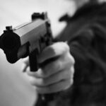 Federal Facility Assault Sparks Massive Sentences Close-up of a person holding a handgun in a threatening manner