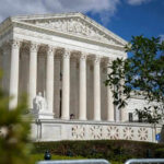 Federal Judge Blocked Without Impeachment Process Large neoclassical building with columns behind trees
