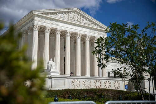 supreme-court-2490549701 Large neoclassical building with columns behind trees