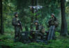 Soldiers operate a drone in a forest