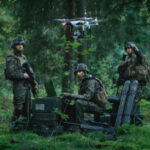 Soldiers operate a drone in a forest