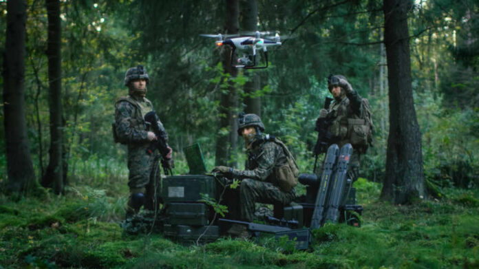 Soldiers operate a drone in a forest