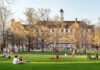Federal Court Sides With Texas On Tuition Law Students relaxing on a campus quad in front of a brick academic building