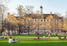 Federal Court Sides With Texas On Tuition Law Students relaxing on a campus quad in front of a brick academic building