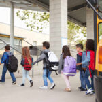 Group of children walking towards a school bus