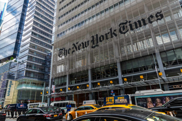 The New York Times building with traffic and yellow cabs in front