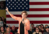 Can Washington Really Tax Its Way Out? A woman speaking into a microphone with an American flag backdrop