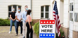 Voters wearing masks line up outside a polling place