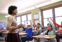 The Next Education Battle Starts With Climate Teacher engaging with students raising hands in a classroom