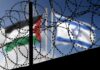 Barbed wire coils with blurred Palestinian and Israeli flags in background