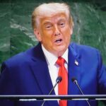 Trump Reignites Election Security Debate Before Midterms A man in a blue suit delivering a speech at a podium