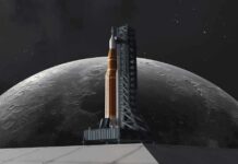 A rocket on a launch pad with the moon in the background