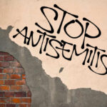 Political Rhetoric Sparks Fresh Antisemitism Concerns Stop antisemitism graffiti on a worn brick wall