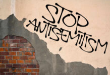 Political Rhetoric Sparks Fresh Antisemitism Concerns Stop antisemitism graffiti on a worn brick wall