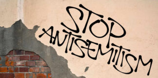 Stop antisemitism graffiti on a worn brick wall