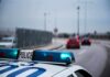 Police car with blue lights on near a roadway