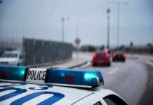 Police car with blue lights on near a roadway