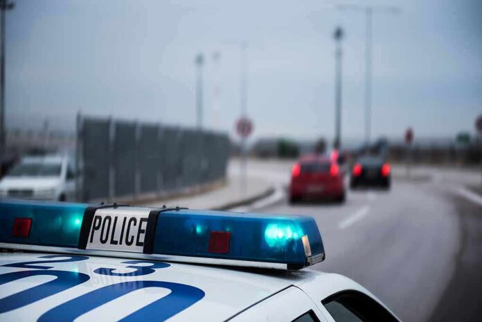 Police car with blue lights on near a roadway