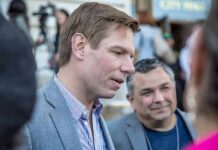 Warrant Drop at SFO — Swalwell Devices Seized Man in a gray blazer speaking at an outdoor event