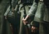 Soldiers in wool uniforms holding rifles