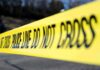 Yellow police tape stretched across an outdoor scene