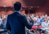 Optics Nightmare: Columbia Elevates Ousted TV Faces Speaker addressing an audience in a conference hall