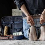 Washington Turns Up The Heat On Cartels Person in handcuffs kneeling beside an open suitcase with cash