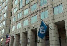 Party Civil War: ICE On Chopping Block U.S. government building facade with American and blue departmental flags