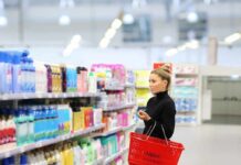 That Bigger Package May Be Hiding Something Woman shopping in a supermarket aisle with a red basket
