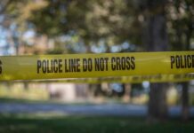 Two Down, Two Cuffed – What Really Happened? yellow police tape cordoning off an outdoor area