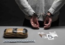 Massive Meth Setup Found – Where’d It Lead? person in handcuffs behind back over table with seized packages