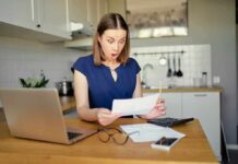 California’s Electric Shock: Double America’s Price Woman in kitchen reacting to a bill at a table with laptop and calculator