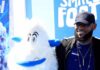 LeBron James posing next to a white yeti mascot at a blue-themed event