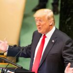 Trump’s Timing Lights Up 9/11 speaker in suit gestures at podium