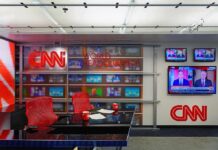 CNN newsroom set with red chairs and multiple TVs