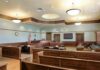 Child-Cruelty Verdict Explodes Campaign Empty courtroom with wooden benches and judge's bench