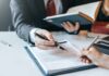 Families Revolt: 9/11 Pen Stunt Hands signing a legal document at a desk