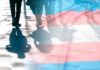 trans pride flag overlaying silhouettes of people walking on a city street