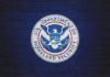 U.S. Department of Homeland Security seal on a blue brick wall