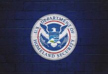 U.S. Department of Homeland Security seal on a blue brick wall