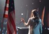 Freedom Alarm From a North Korean Escapee American flag and speaker at podium addressing audience
