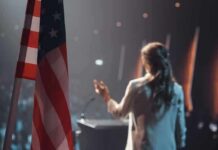 American flag and speaker at podium addressing audience