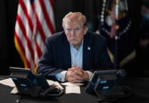 A TV Disclaimer Just Sparked A Washington Fight Donald Trump seated at a table between two desk phones
