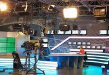 News studio with anchor at desk and cameras