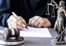 Rights Restored? New Path Stuns Critics Judge writing at desk with gavel and Lady Justice statue