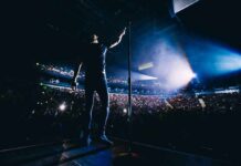 Singer on stage facing a large concert crowd
