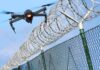Drone flying near barbed wire security fence