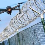 Drone Factories Land at Center of Espionage Case Drone flying near barbed wire security fence